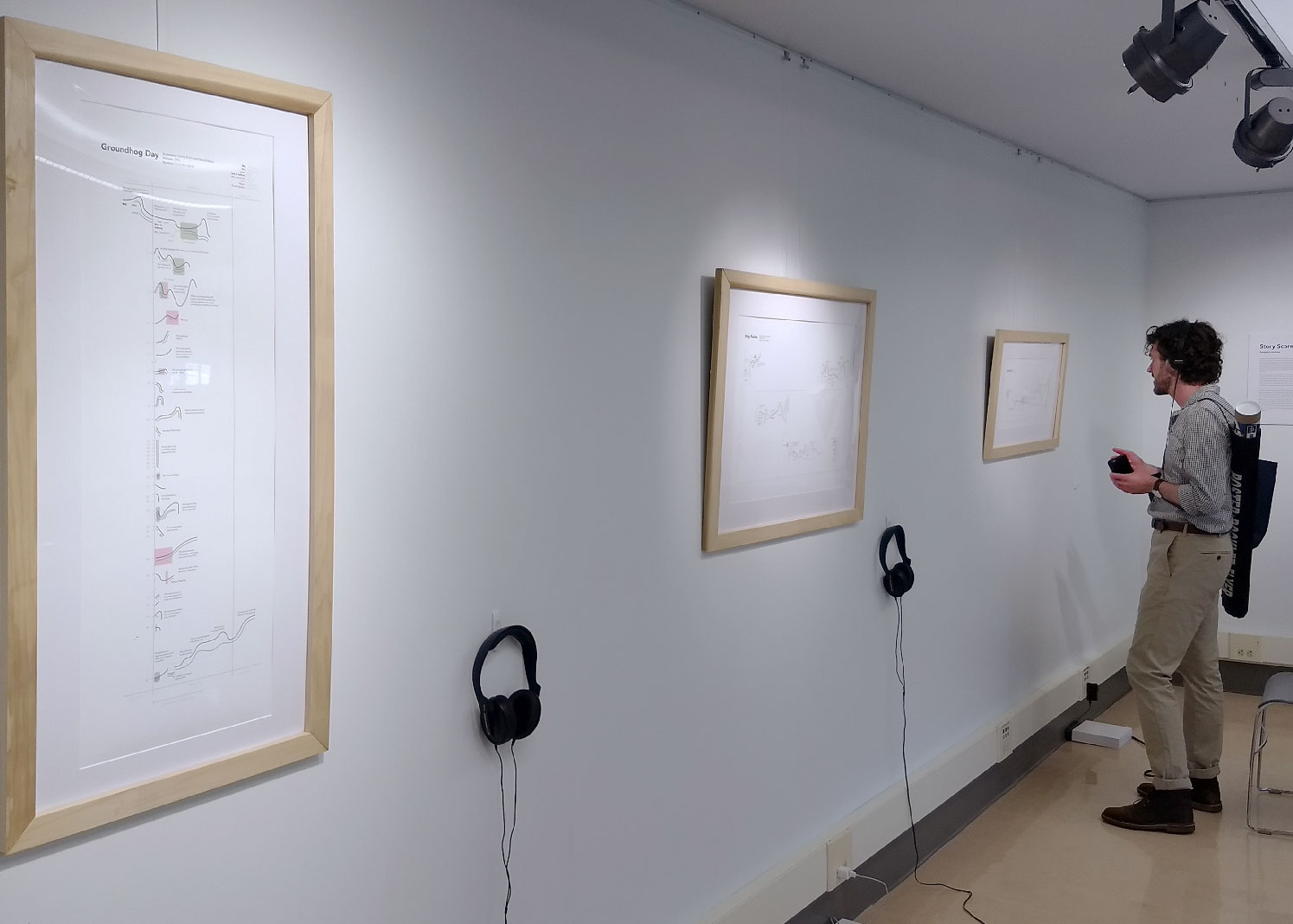Frames prints in a gallery with headphones hanging below each one.