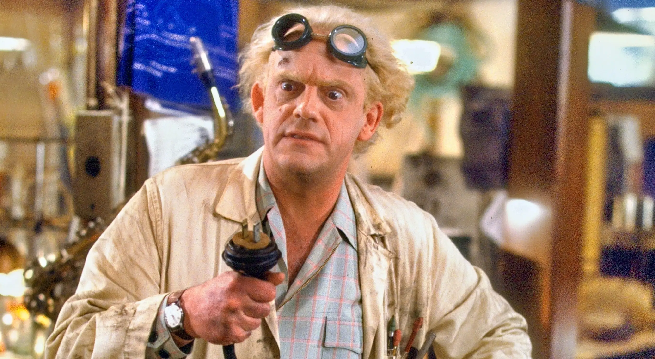 A film still of Doc Brown from Back to the Future, a frizzy-haired scientist holding a cable